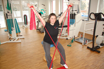 Bild zeigt eine Frau mit Theraband