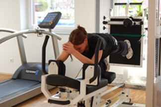 Bild zeigt eine Frau die im Trainingsraum trainiert